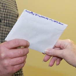 Ein Brief wird zwischen zwei Händen übergeben. (Bild: LWL)
