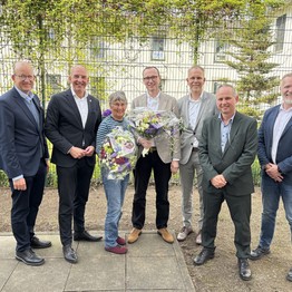 Eine Gruppe von Menschen steht in einem eingezäunten Innenhof (LWL-Bild: SchuFi)