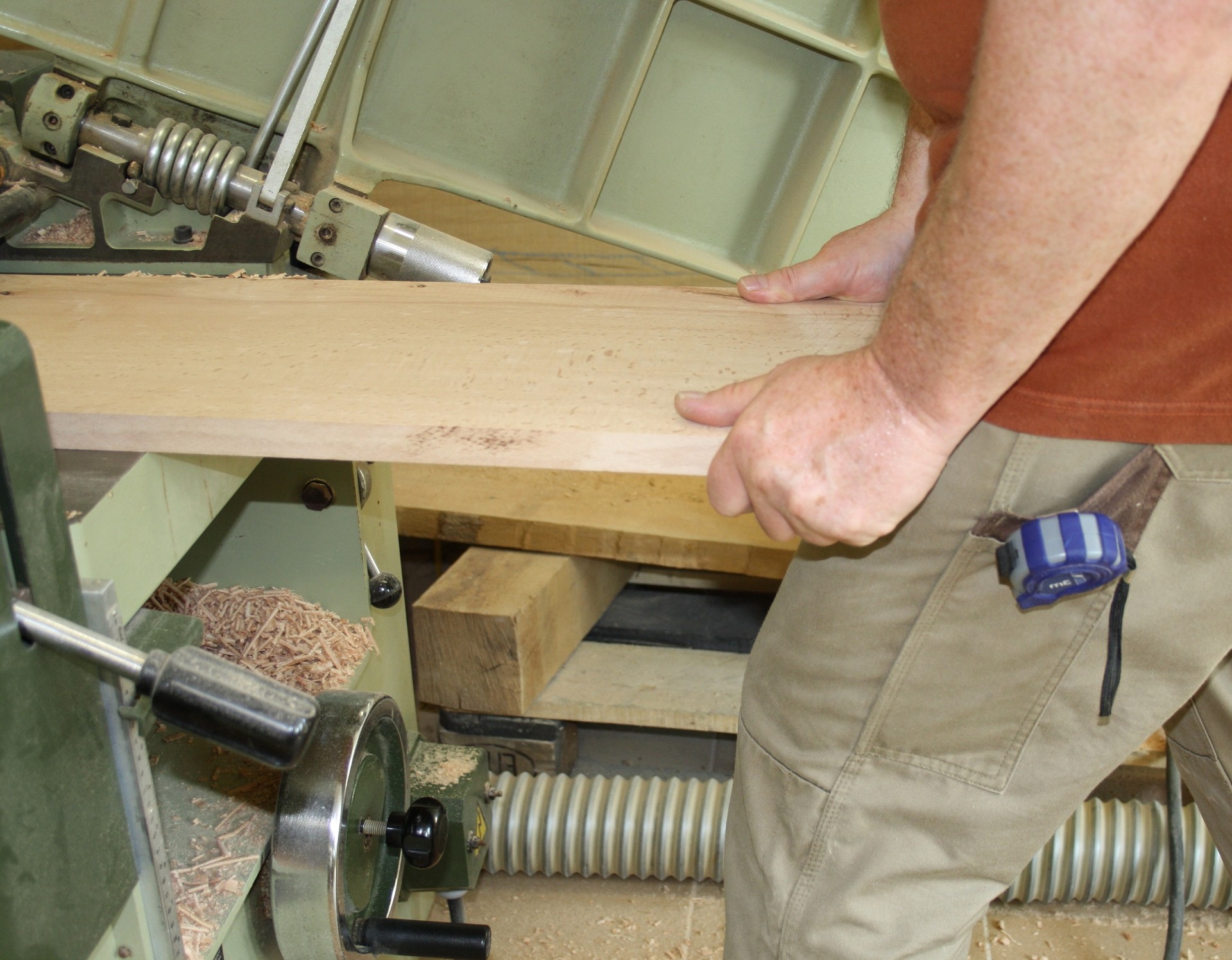 Jemand arbeitet an einer Maschine mit einem Holzbrett. (Bild: LWL/SchuFi)